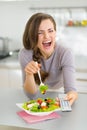 Laughing woman eating salad and watching tv Royalty Free Stock Photo