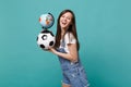 Laughing woman football fan support favorite team with soccer ball Earth world globe isolated on blue turquoise
