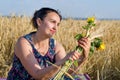 Laughing woman holding flowers in a wheat field Royalty Free Stock Photo