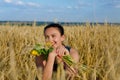 Laughing woman holding flowers in a wheat field Royalty Free Stock Photo
