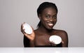 Laughing african woman with moisturizing cream on her face. Portrait of african american woman with flawless skin on white Royalty Free Stock Photo