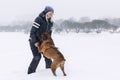 Laughing woman plays with boxer dog in winter park. Love and friendship Royalty Free Stock Photo