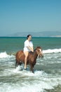 Laughing woman rides horse in water sea Royalty Free Stock Photo