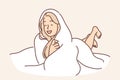 Laughing woman wrapped in blanket lies on bed not wanting to get up and go to work or college Royalty Free Stock Photo