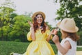 Laughing woman in yellow clothes play in park have fun, amuse with little cute child baby girl hold soap bubble blower Royalty Free Stock Photo