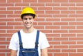 Laughing worker in front of a brick wall