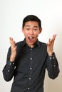 Laughing young Asian man gesturing with hands and looking at cam Royalty Free Stock Photo