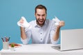 Laughing young bearded man in light shirt work at desk with pc laptop isolated on pastel blue background. Achievement Royalty Free Stock Photo