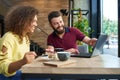 Laughing boy and girl using computer sitting in restaurant.