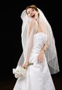 Laughing young bride in wedding dress and veil