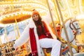 Laughing young woman at the winter fair riding a horse, carousel, Christmas carelessness and fun.