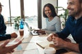 Laughing young businesswoman sitting with colleagues in an offic Royalty Free Stock Photo