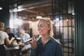 Laughing young businesswoman talking on speakerphone in an offic Royalty Free Stock Photo