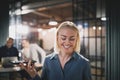 Laughing young businesswoman talking on speakerphone in an offic Royalty Free Stock Photo