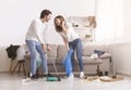 Laughing Young Couple Cleaning Mess In Their Flat After Party