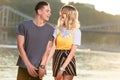 laughing young couple holding hands on river beach in evening and looking Royalty Free Stock Photo