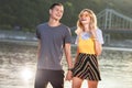 laughing young couple holding hands and walking on river beach Royalty Free Stock Photo