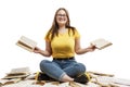 A laughing young girl in jeans and a blue T-shirt sits on a pile of opened books and holds books in her hands. Education and Royalty Free Stock Photo