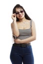 Laughing young girl in jeans. Brunette with long hair wearing sun glasses. Isolated on a white background. Vertical