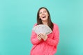 Laughing young girl in knitted pink sweater looking up hold in hand lots bunch of dollars banknotes cash money isolated