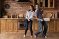 Laughing young hispanic family couple dancing in kitchen. Royalty Free Stock Photo