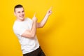 Laughing young man pointing away at copy space with two fingers. Banner copy spase Royalty Free Stock Photo