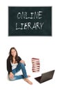 Laughing young student or elder schoolgirl with a huge pile of books and a laptop in front of a blackboard Royalty Free Stock Photo