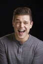 Laughing young white man looks to camera, vertical portrait Royalty Free Stock Photo
