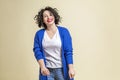 Laughing young woman. Beautiful bright curly brunette in jeans, a white T-shirt and a blue jacket. Positivity and happiness,