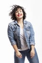 Laughing young woman. Beautiful brunette with curly hair in jeans. Positiveness, energy, youth and happiness. White background.