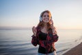 Laughing young woman enjoying the music. Girl in earphones on sea background Royalty Free Stock Photo