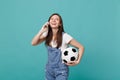 Laughing young woman football fan with soccer ball talking on mobile phone, conducting pleasant conversation isolated on Royalty Free Stock Photo