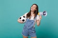 Laughing young woman football fan support favorite team with soccer ball, megaphone isolated on blue turquoise Royalty Free Stock Photo