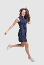 Laughing young woman jumping, having fun and enjoying life, beautiful joyful girl full length isolated studio portrait Royalty Free Stock Photo