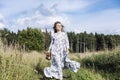 Laughing young woman in a long romantic dress runs in the field on a sunny day. Happiness is in unity with nature Royalty Free Stock Photo