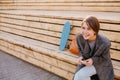 Young laughing woman with a skateboard is sitting on a 2-stage bench. Royalty Free Stock Photo