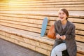 Young laughing woman with a skateboard is sitting on a 2-stage bench Royalty Free Stock Photo