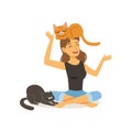 Laughing young woman sitting with legs crossed. Red cat on girl s head, black cat next to hostess. Female character
