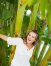 Laughing young woman among tropical palms