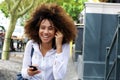 Laughing young woman walking with cellphone and earphones Royalty Free Stock Photo