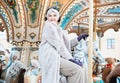 Laughing young woman at the winter fair riding a horse, carousel Royalty Free Stock Photo