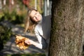 Laughingblond woman, picking up, holding bunch of golden foliage yellow leaves maples in two hands, decorate blur. Close Royalty Free Stock Photo