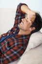 Laughter of relief. A gorgeous young man lying down and smiling with his arm behind his head.