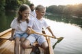 Lauging boy and girl paddling canoe with their father