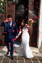 Smiling and happy young married couple leaving church after marriage. Lake Garda, Torri del Benaco, Italy. Royalty Free Stock Photo