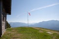 Launch site of paragliders with red and white windsocks and wooden hut. In the background mountain peaks in the German Alps Royalty Free Stock Photo