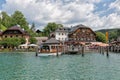 Launch with tourists mooring to wooden pier in lake Konigssee