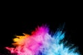 Launched colorful powder on black background.Color powder explosion.Colorful dust splashing