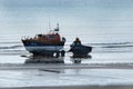 Launching lifeboat from beach at low tide.