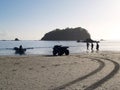 Launching surf-boat at sunrise in silhouette on Mount Maunganui ocean beach